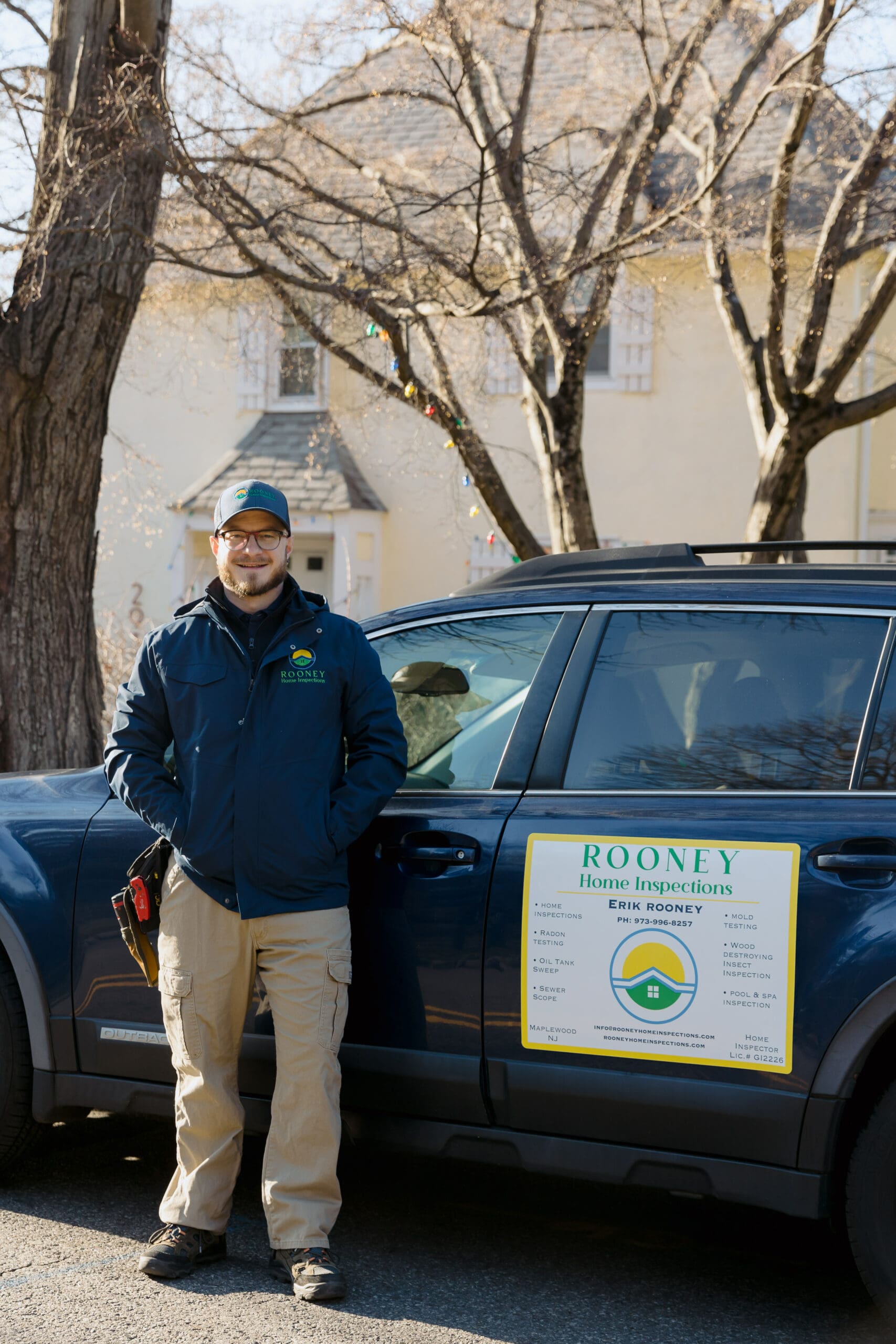 Erik Rooney beside the Rooney Home Inspections vehicle