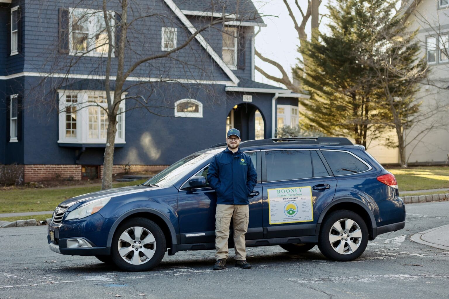 Erik Rooney beside the Rooney Home Inspections vehicle
